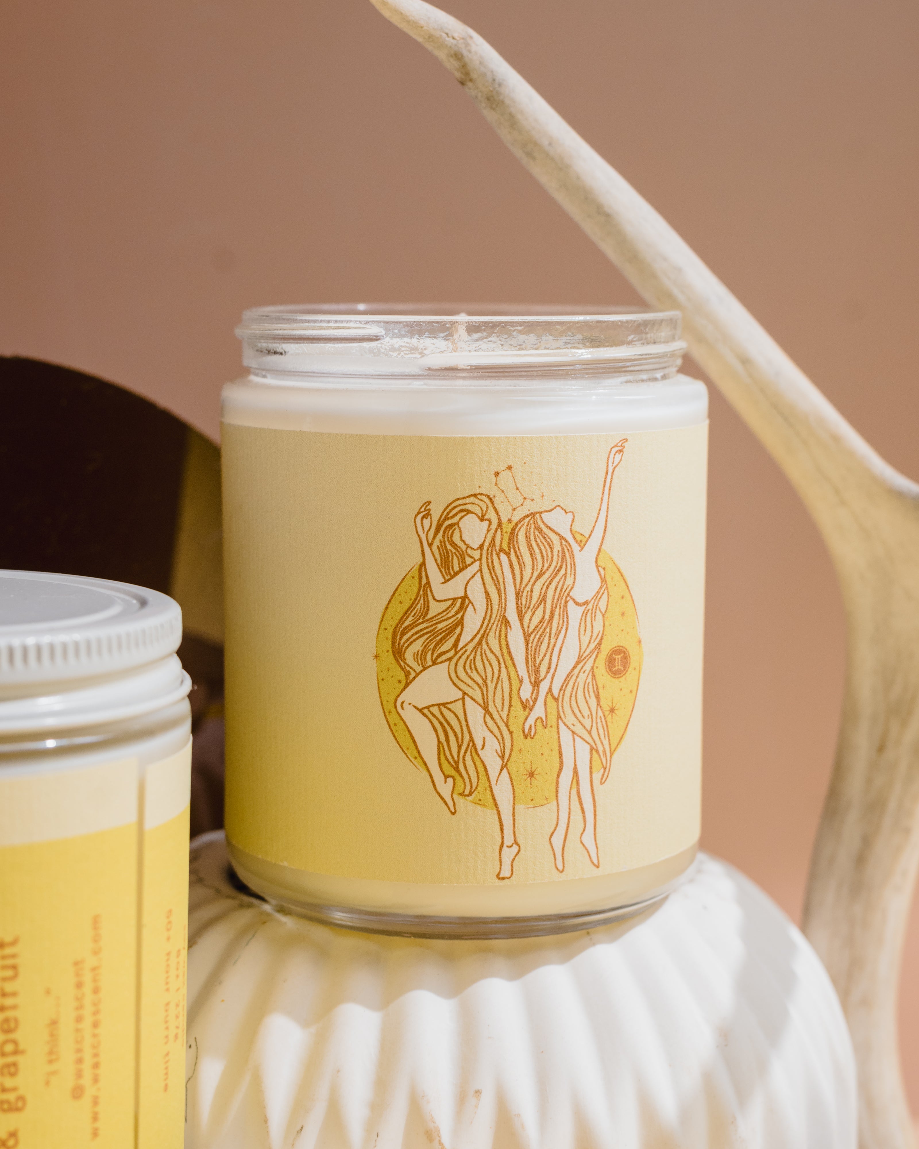 gemini candle with yellow and orange. image of twins the sign of gemini in the zodiac.