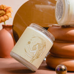 Hand-poured soy wax Aries candle from Wax Crescent, displayed with earthy decor and a single orange flower