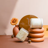 Wax Crescent zodiac candle for Aries with Sugar & Smoke fragrance, styled with gold spheres and sculptural stand