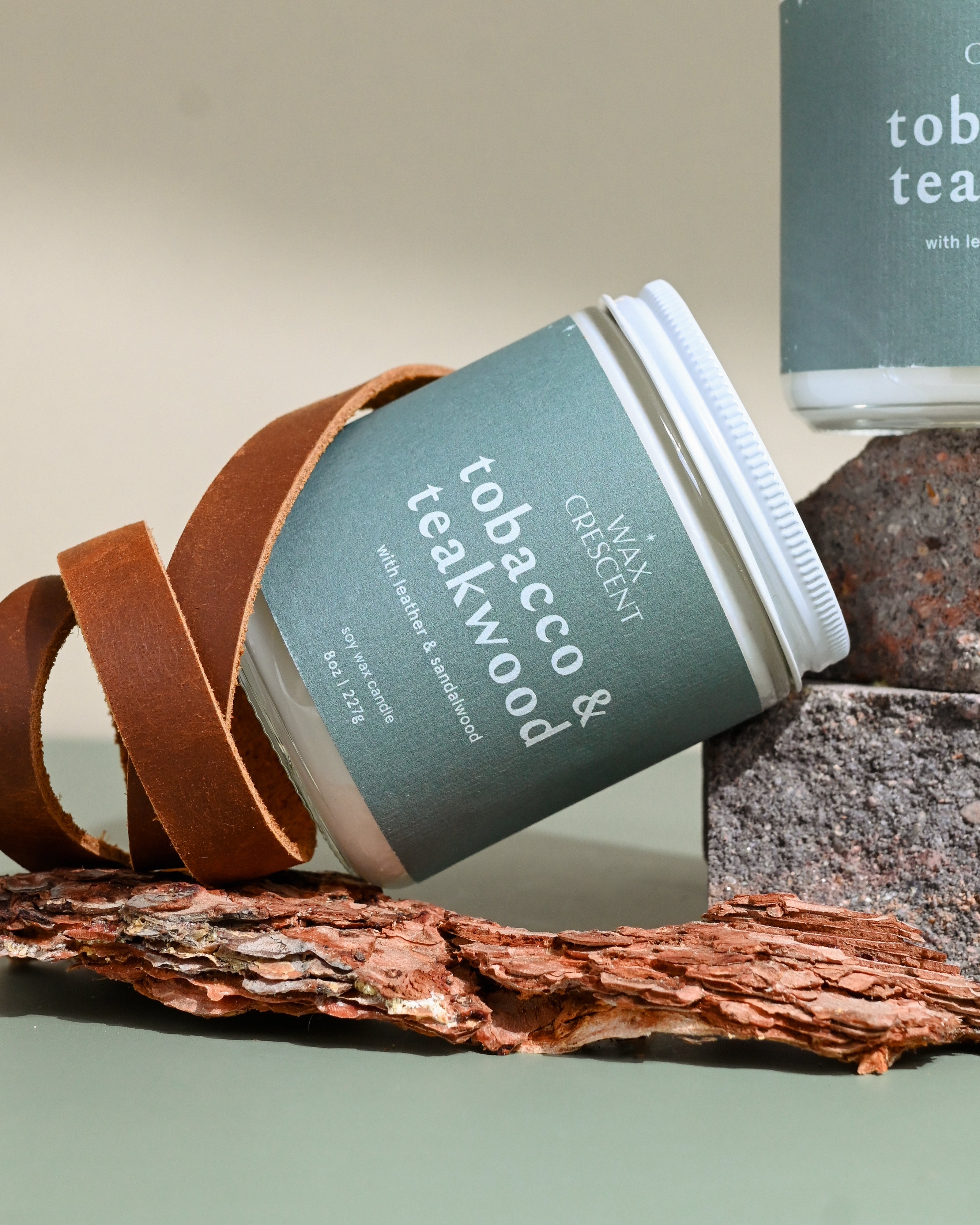 Close-up of Wax Crescent Tobacco & Teakwood candle featuring leather, bark, and earthy tones. A luxury soy candle for a warm and inviting atmosphere