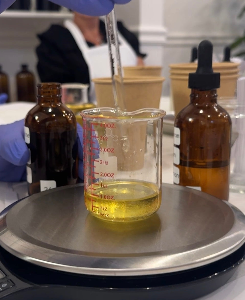 the art of blending scents in a candle making workshop in Longmont Colorado make your own candles. Someone adding oil to a mixture 