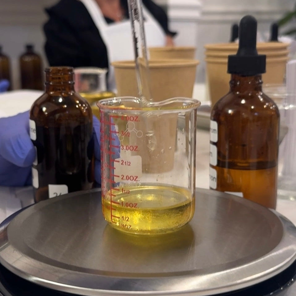 the art of blending scents in a candle making workshop in Longmont Colorado make your own candles. Someone adding oil to a mixture 