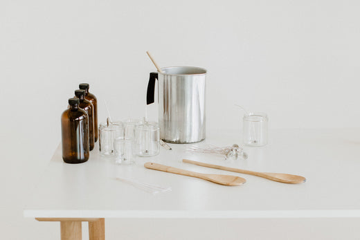 table with candle making supplies, a pour pitcher for soy wax, jars and nontoxic fragrance oils