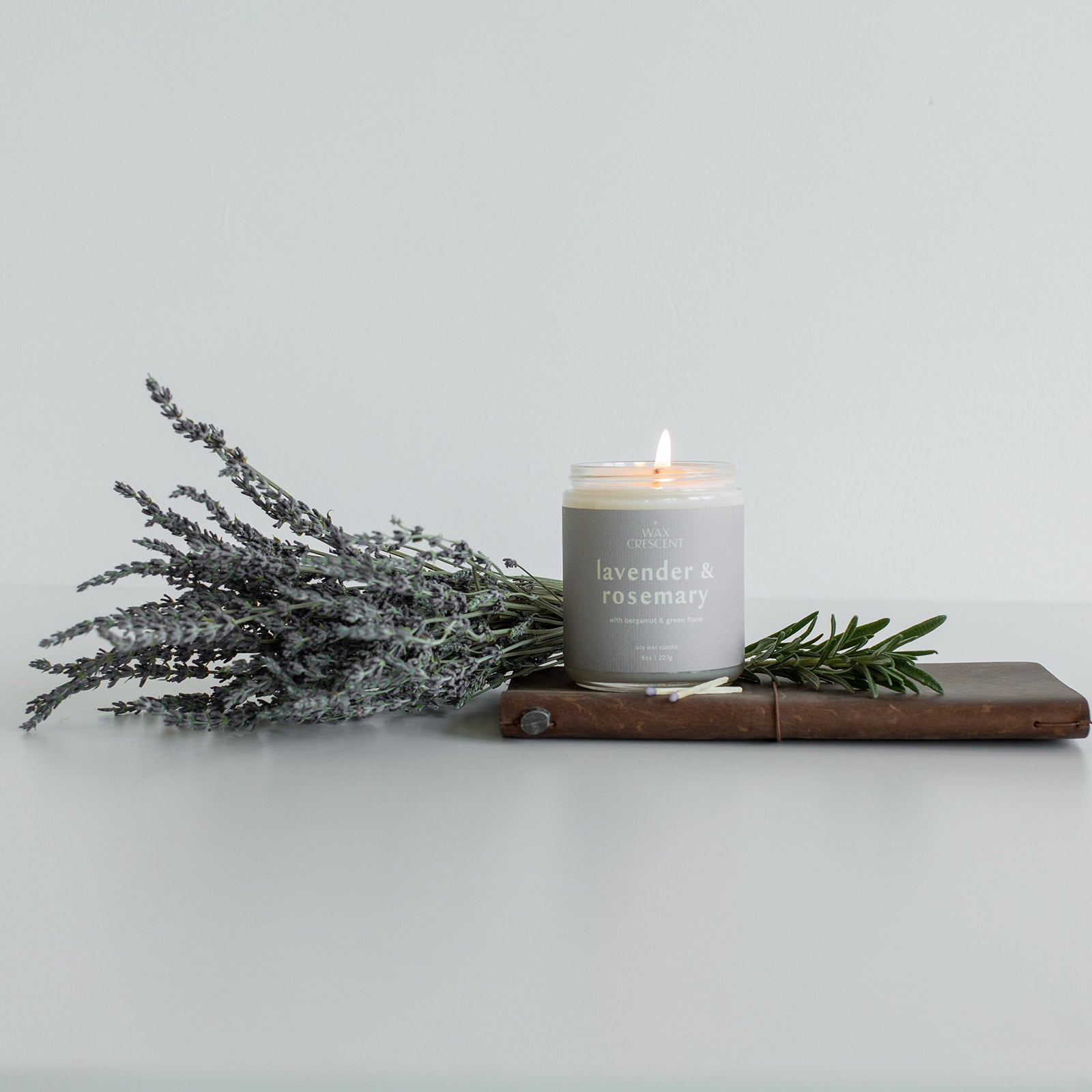 lavender and rosemary candle for mothers day it is the perfect gift the candle is pictured surrounded by fresh lavender. 