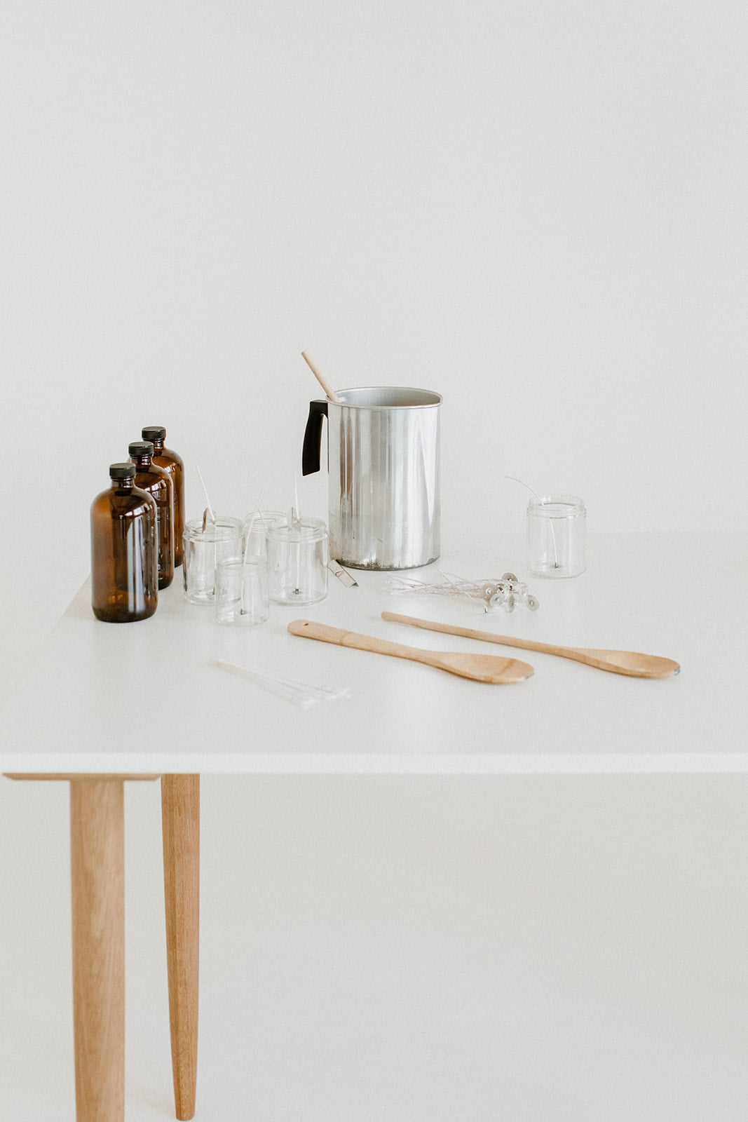 candle making table with everything needed for candle making classes: pour pitcher, fragrance bottles 