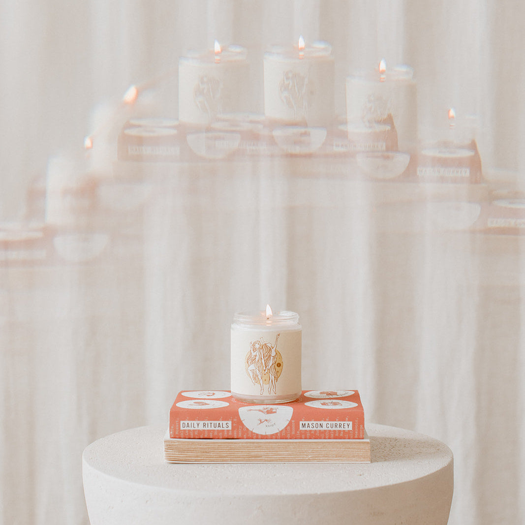 gemini zodiac candle on a stack of books where each astrology sign honors the elements of the zodiac 