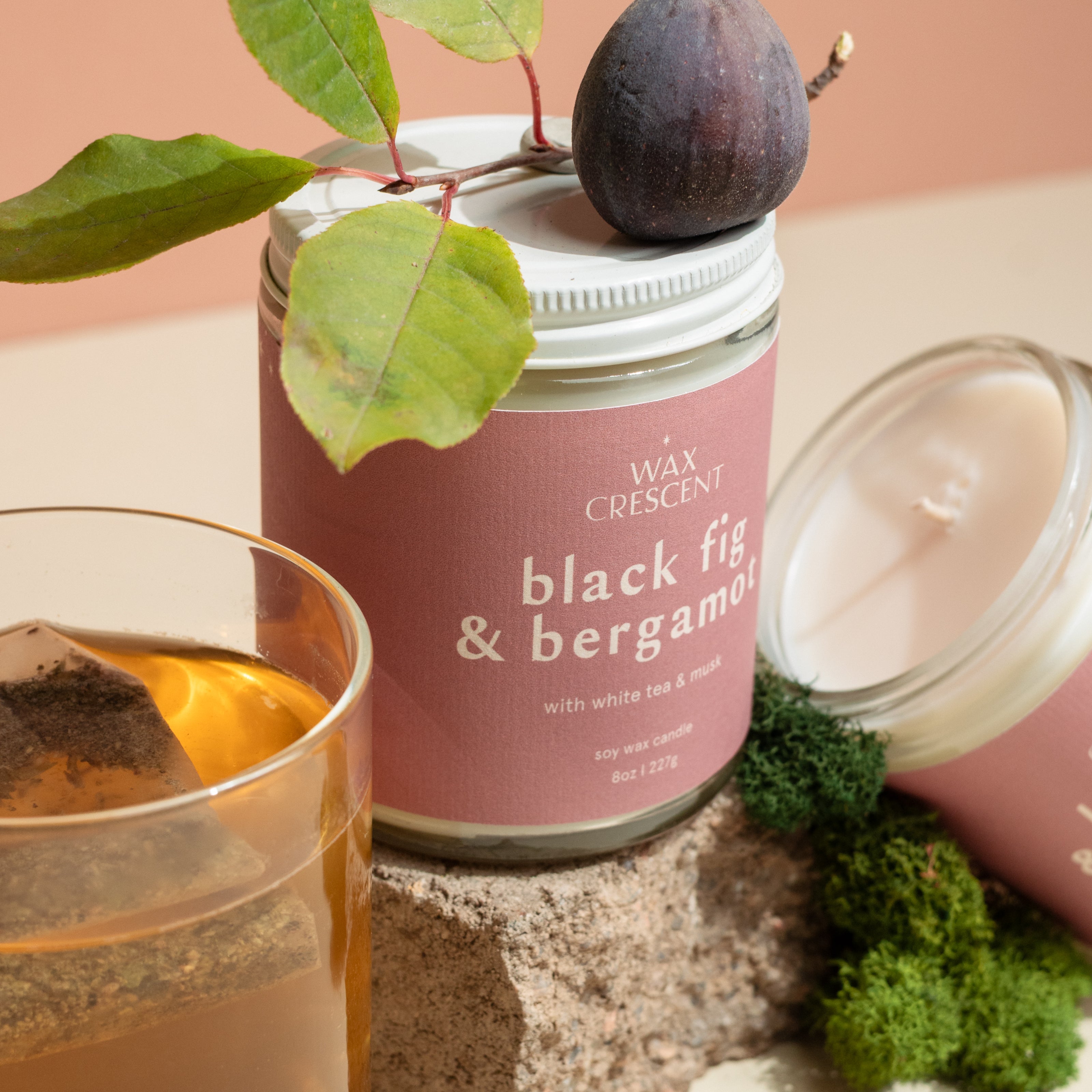 Rosemary & Cedarwood luxury soy candle styled with natural birch wood and fresh rosemary sprigs, evoking a soothing, earthy ambiance from Wax Crescent’s Signature Scents Collection.