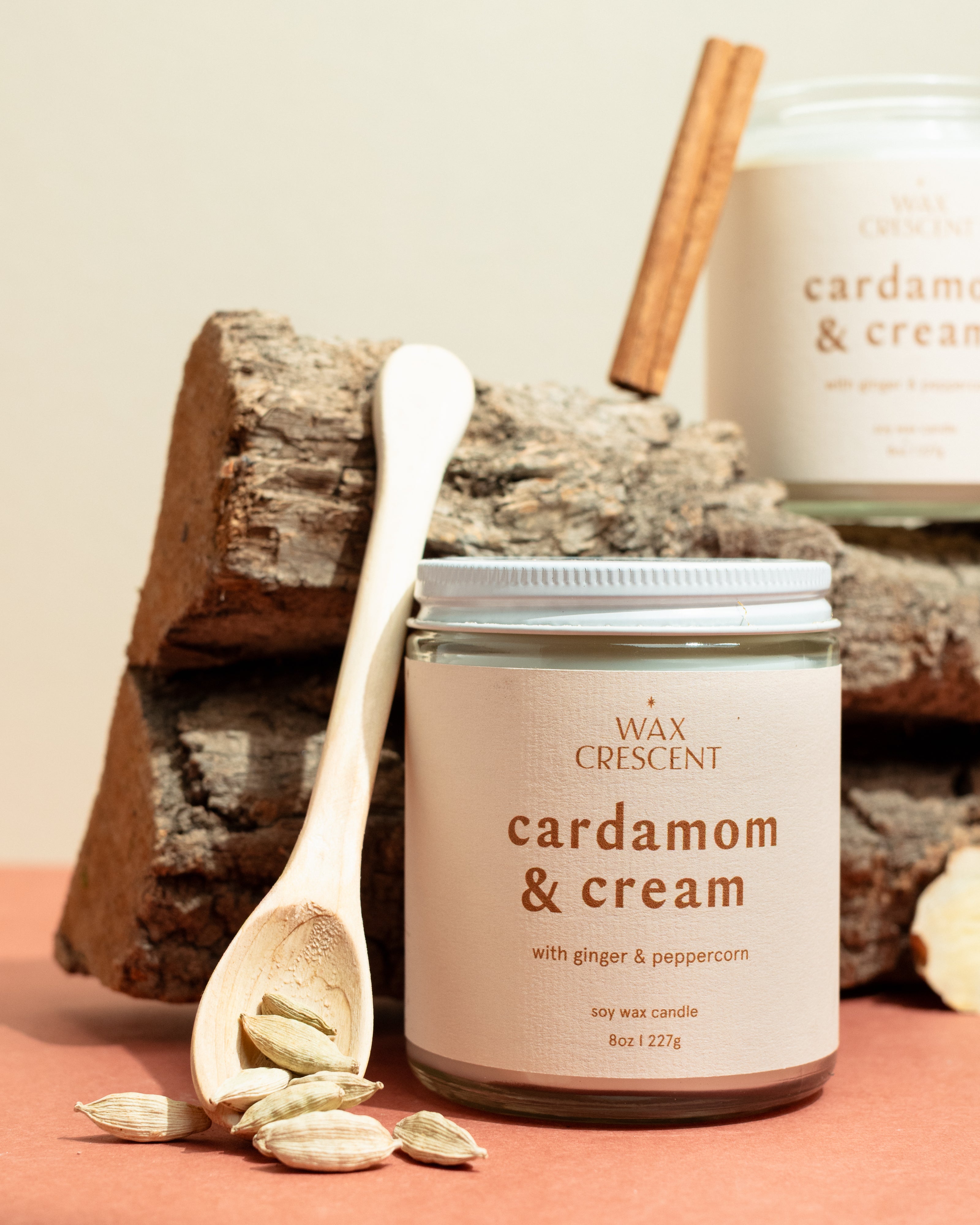 Cardamom & Cream candles styled with cinnamon and cardamom on wood — elegant non-toxic holiday candles hand-crafted by Wax Crescent, the perfect cozy gift for the season.