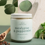 Hand-poured Eucalyptus & Peppermint candles from Wax Crescent, photographed with eucalyptus leaves and pine — a fresh, festive scent that captures the spirit of the season
