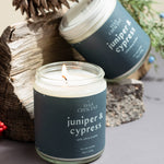 Pair of Juniper & Cypress candles with natural decorative elements on a neutral background — small-batch soy candles from Wax Crescent that bring fresh evergreen calm to any space