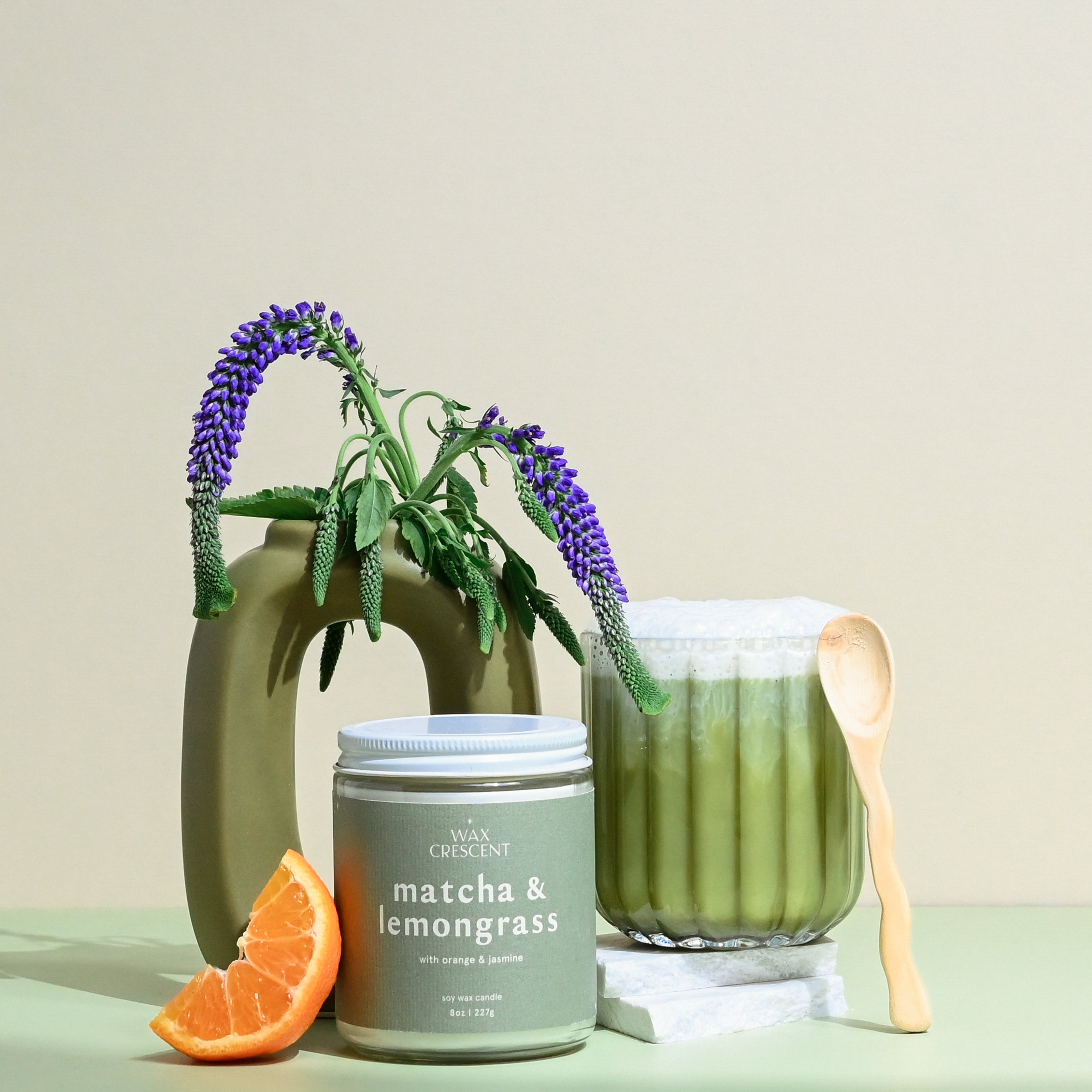 Wax Crescent Matcha & Lemongrass soy candle with green tea, orange, and jasmine notes, styled with greenery and a matcha latte for a refreshing, non-toxic ambiance.