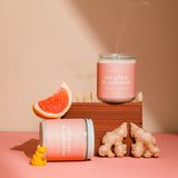 Candle with 'Red Ginger & Cardamom' scent on a pink background