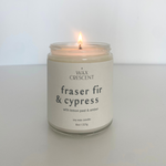 Lit Fraser Fir & Cypress soy wax candle on a neutral background, highlighting its clean, minimalist design and calming forest scent.