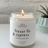 Fraser Fir & Cypress soy candle lit, featuring a minimalist white label with a clean background and a potted plant, hand-poured in Colorado