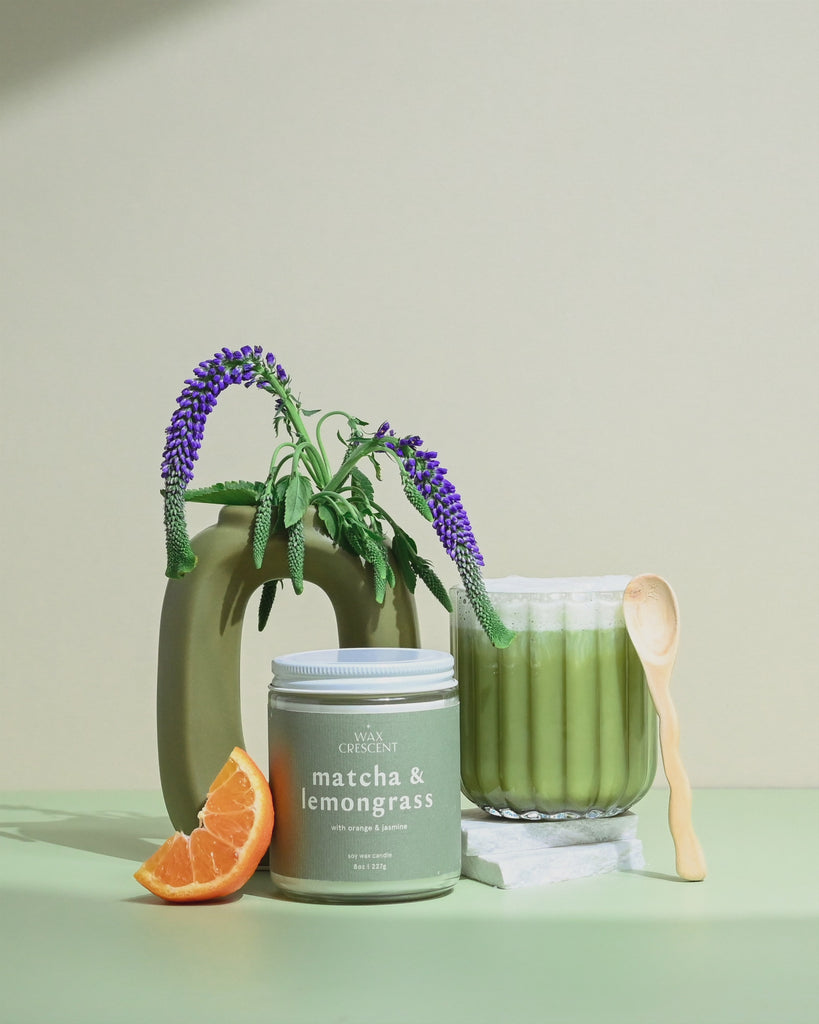 Wax Crescent Matcha & Lemongrass soy candle with green tea, orange, and jasmine notes, styled with greenery and a matcha latte for a refreshing, non-toxic ambiance.