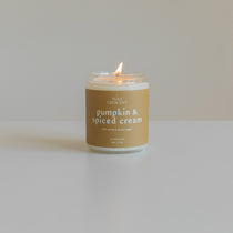 Pumpkin & Spiced Cream soy candle by Wax Crescent, burning with a cozy glow, featuring warm notes of pumpkin, vanilla, and cinnamon for a perfect fall ambiance