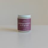 Pomegranate & Evergreen soy candle with a minimalist design, featuring a berry-colored label, hand-poured with non-toxic fragrance oils
