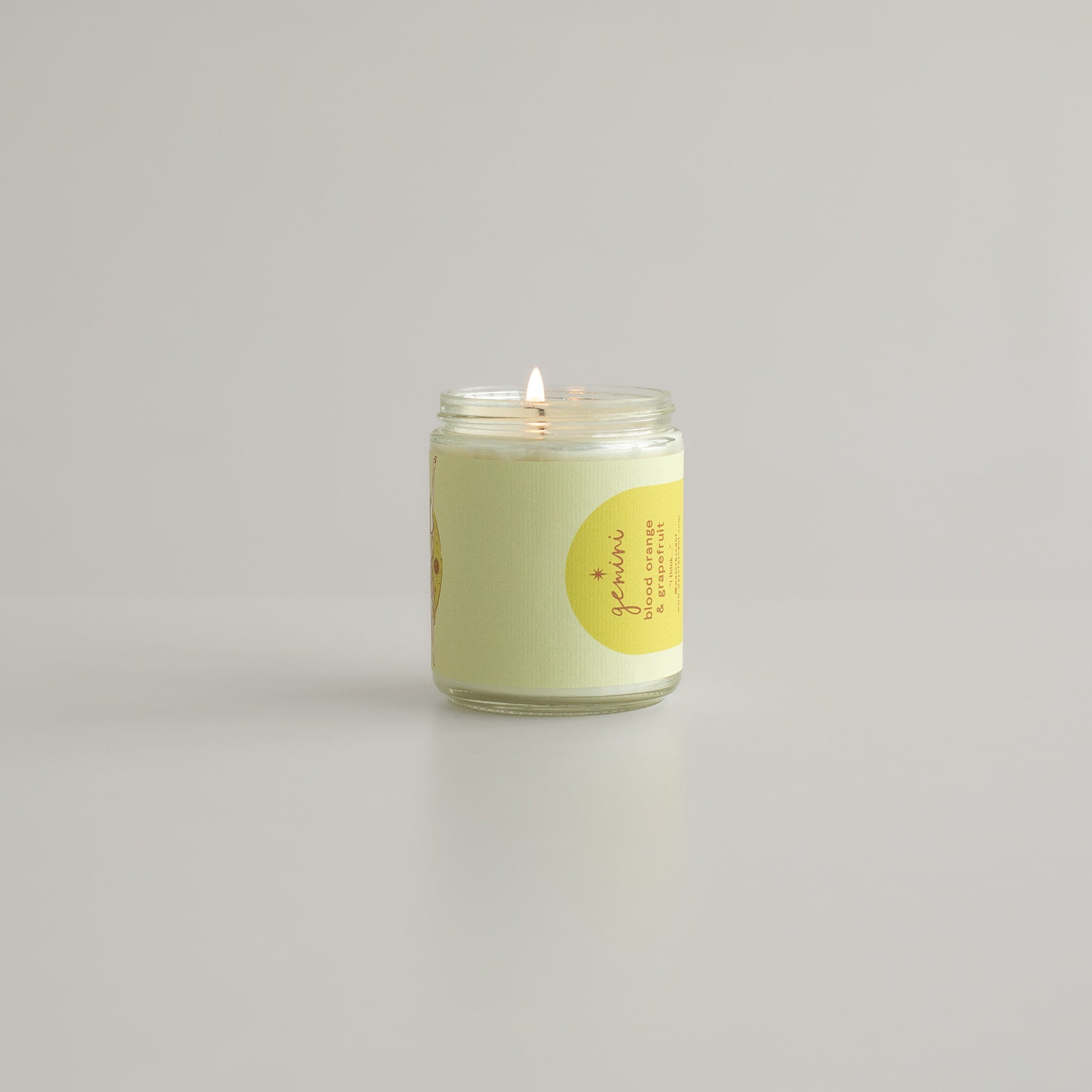 gemini zodiac candle for this astrology sign in a jar with yellow and orange label featuring gemini twins
